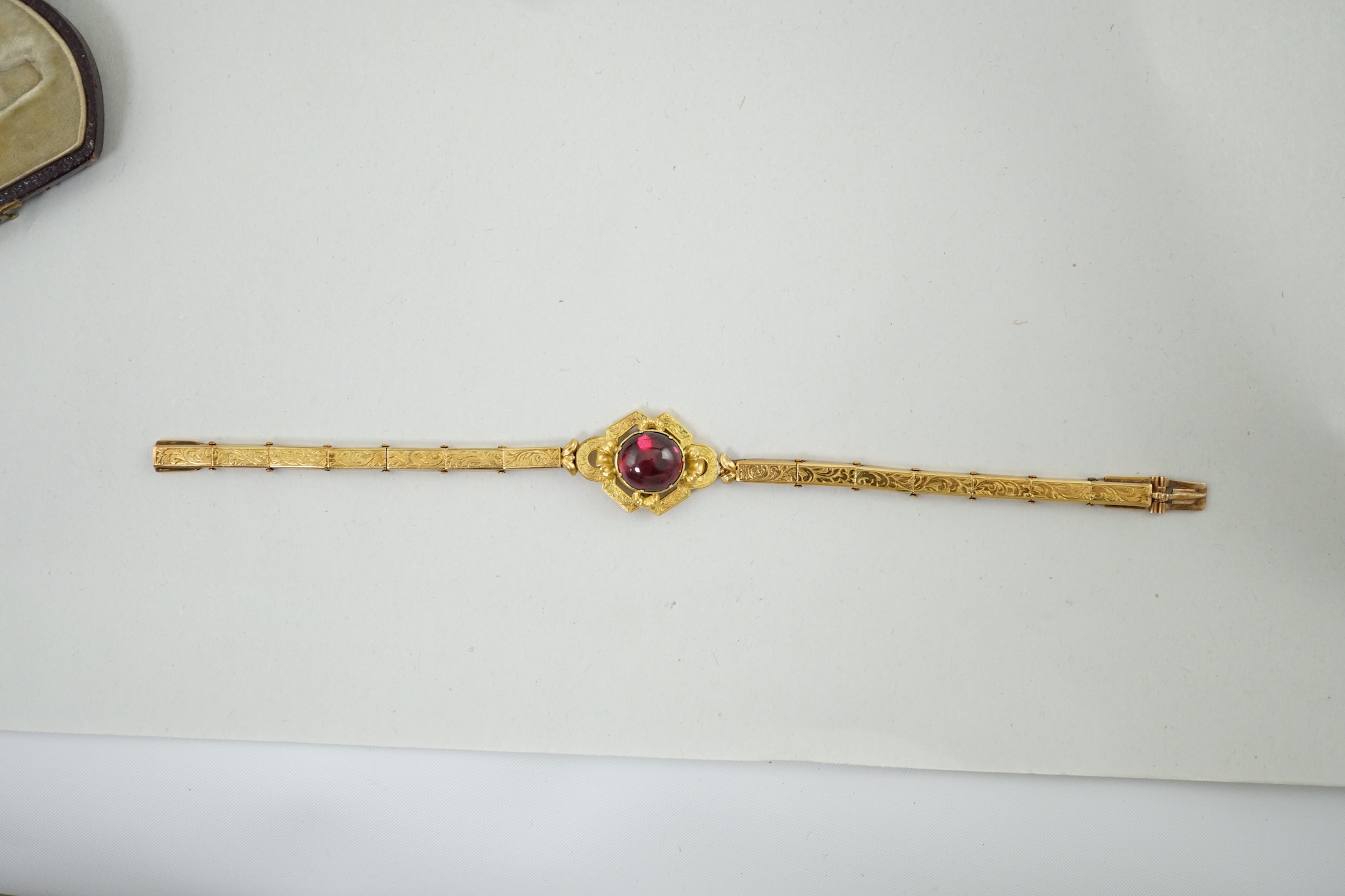 An early 19th century engraved gold and cabochon garnet set mourning bracelet